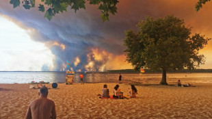 Many thousands flee burning France holiday haven by road and sea